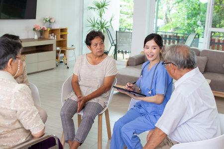 asian senior patient and nurse discussing with senior people in nursing homeの写真素材