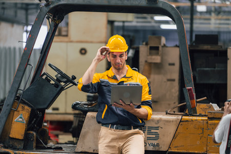 Caucasian engineer using a laptop in a factory. man working in plastics factory.の写真素材