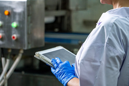 caucasion woman working in a food factory wearing protective clothes and glovesの写真素材