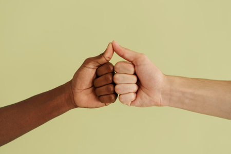 Close-up of male and female hands showing thumbs up gesture isolated over green backgroundの写真素材