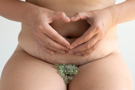 Close up of pregnant woman making heart with hands on her belly.の写真素材