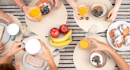 Top view of group of people having breakfast at wooden table, closeup
