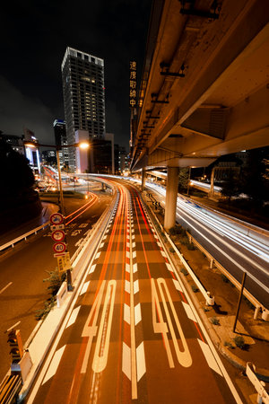 A high angle shot of a long exposure of a busy highway at night