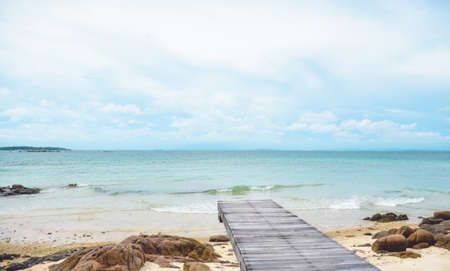 Wooden bridge on the beach and rocks, cloudy and blue sky , summer backgroundの写真素材