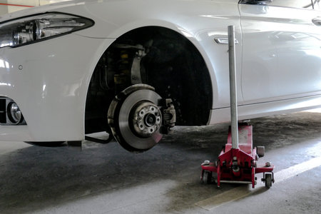 Car lift up for tyre replacement in parking. used floor jack for tyre replacement