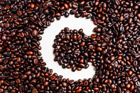 Coffee beans arranged in the shape of Letter C on white background top viewの写真素材