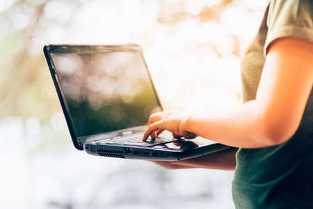 A woman pointing finger to the keyboard laptopの写真素材