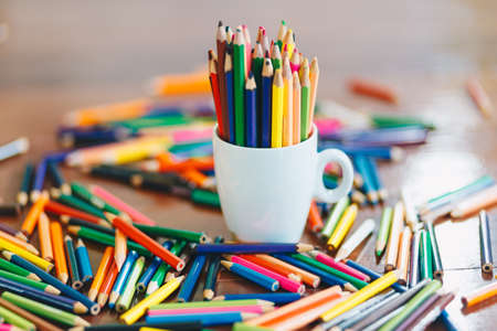 colored pencils in a glass on wooden backgroundの写真素材