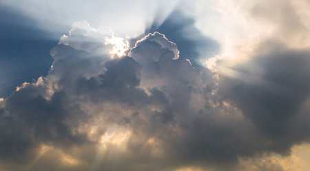 Beautiful blue sky with sunbeams and clouds. Sun rays.