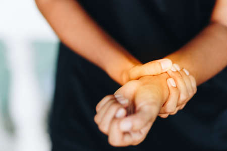 Woman holding her wrist painの写真素材