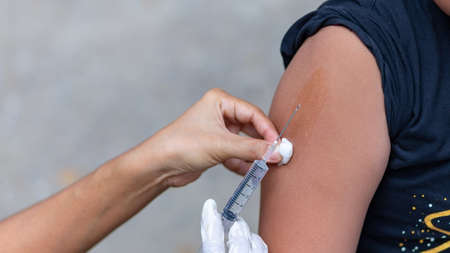 Doctor give injection to boy's arm , healthy and medical conceptの写真素材
