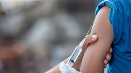 Doctor give injection to boy's arm , healthy and medical conceptの写真素材