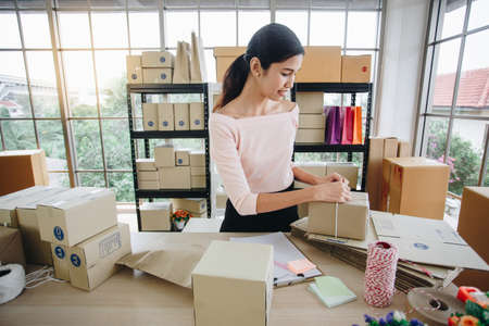 Woman is handing package box from online shoppingの写真素材