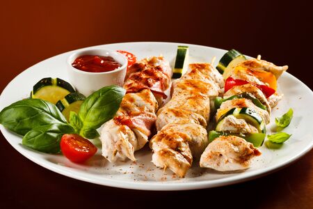 Chicken skewer roasted on skewer of vegetables tomatoes sauce serving dinner dinnerの写真素材