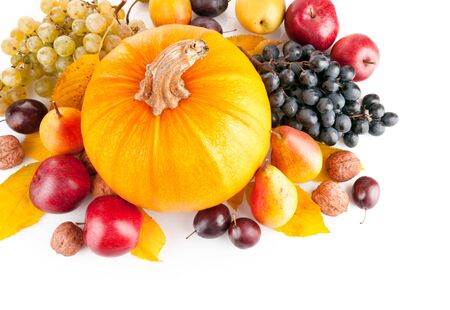 Fruit pumpkin grapes walnuts pear plums on a white backgroundの写真素材
