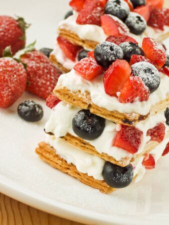 Cake layered baking cream cream blueberry strawberry berries on a white dishの写真素材