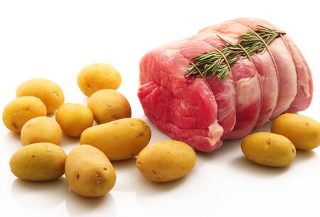 Raw meat, raw potatoes and greens vegetable on white background.の写真素材