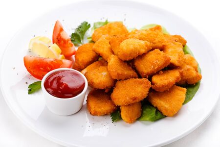 Nuggets chicken fillet sauce tomatoes plate white background .の写真素材