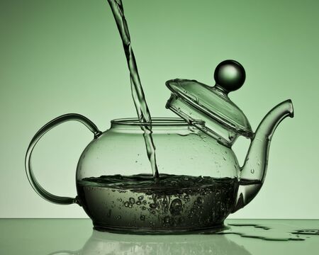 kettle pours water gray green color .の写真素材