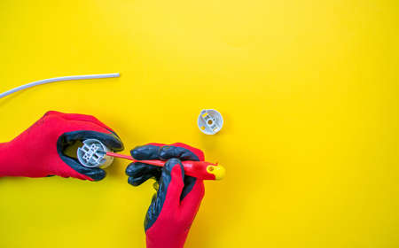 Electrician peeling off insulation from wires - closeup on hands and pliersの写真素材