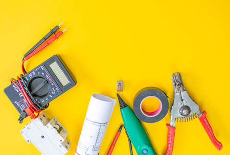 Electrician peeling off insulation from wires - closeup on hands and pliersの写真素材