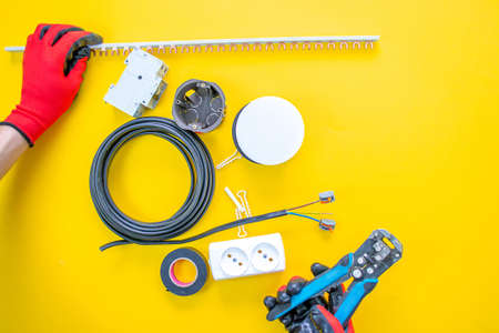 Electrician peeling off insulation from wires - closeup on hands and pliersの写真素材