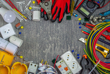 Electrical tools and a set of components for use in electrical installations on a gray background with a place for textの写真素材