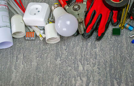 Electrical tools and a set of components for use in electrical installations on a gray background with a place for textの写真素材