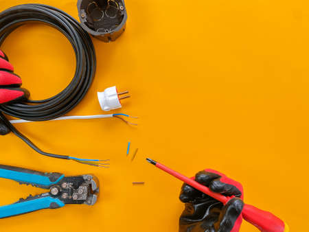 Electrician tools on orange background with copy space for text. Photos for the workshop and the store of building materials. Selective focus.の写真素材
