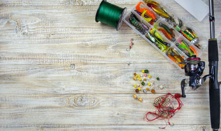 lot of colorful lures with the fishing rod on the wooden pierの写真素材