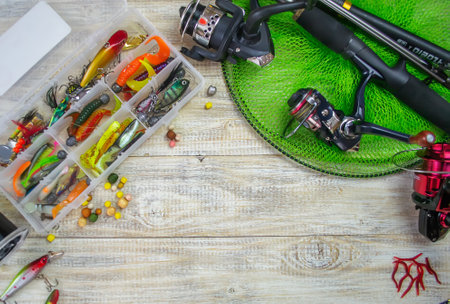 Fishing tackle, many colorful baits with a fishing rod on a wooden pier. Selective focusの写真素材