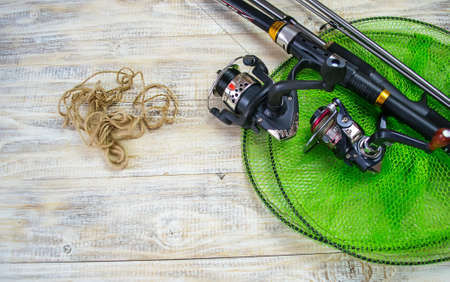 Fishing tackle, many colorful baits with a fishing rod on a wooden pier. Selective focusの写真素材