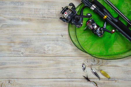 Fishing tackle, many colorful baits with a fishing rod on a wooden pier. Selective focusの写真素材
