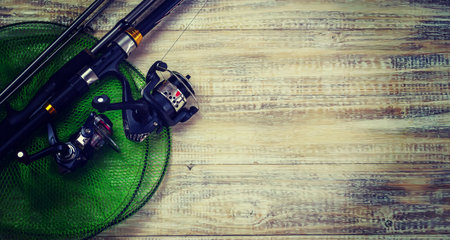 Fishing tackle, many colorful baits with a fishing rod on a wooden pier. Selective focusの写真素材