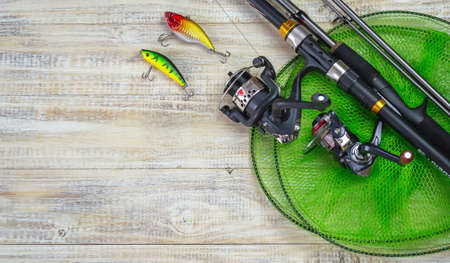 Fishing tackle, many colorful baits with a fishing rod on a wooden pier. Selective focusの写真素材
