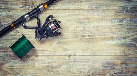 Fishing tackle, many colorful baits with a fishing rod on a wooden pier. Selective focusの写真素材