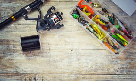 Fishing tackle, many colorful baits with a fishing rod on a wooden pier. Selective focusの写真素材