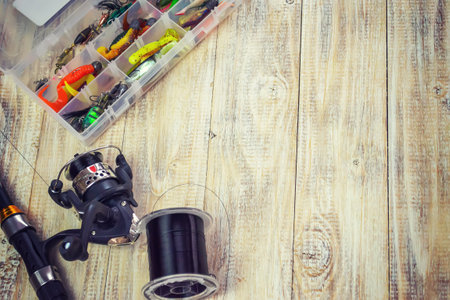 Fishing tackle, many colorful baits with a fishing rod on a wooden pier. Selective focusの写真素材