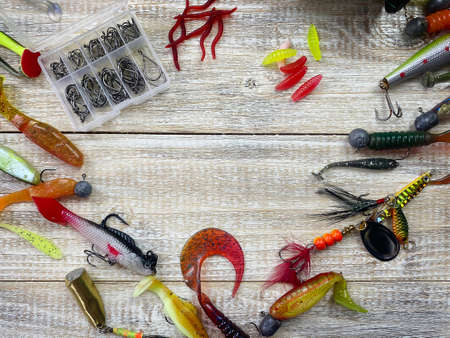 Spinning rod, reel and fishing baits isolated on wooden background, top viewの写真素材