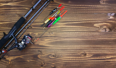 Spinning rod, reel and fishing baits isolated on wooden background, top viewの写真素材