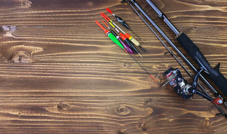 Spinning rod, reel and fishing baits isolated on wooden background, top viewの写真素材