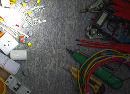 Electrical tools and a set of components for use in electrical installations on a gray background with a place for textの写真素材