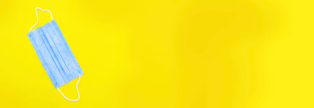 Hand in glove holding model airplanes on yellow background. Airplane model on hand and face medical mask Concept traveling.の写真素材