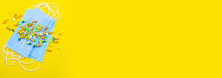 Hand in glove holding model airplanes on yellow background. Airplane model on hand and face medical mask Concept traveling. Copy spaceの写真素材