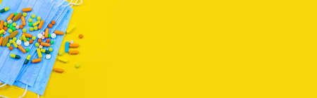 Hand in glove holding model airplanes on yellow background. Airplane model on hand and face medical mask Concept traveling. Copy spaceの写真素材