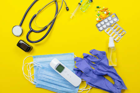 medical supplies on a yellow background, pills water treatment mask virus. Selective focusの写真素材