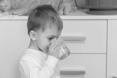 The child drinks water from a glass.の写真素材