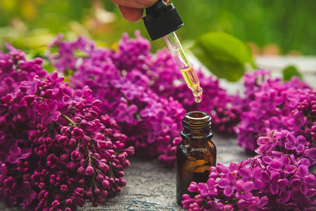 Lilac essential oil in a small bottle. Selective focus. Nature.の写真素材