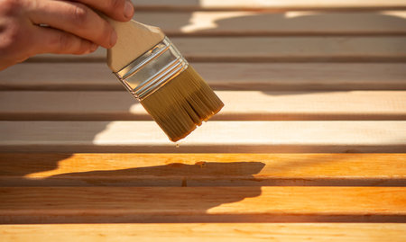 Painting wooden furniture with varnish. a man hides a tree with varnish. Selective focus