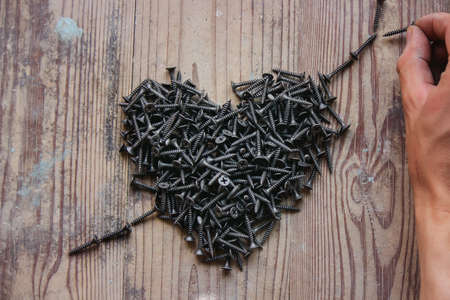 self-tapping screws on a wooden background, a selection of different self-tapping screws for different wall materials and surfaces. Selective focusの写真素材